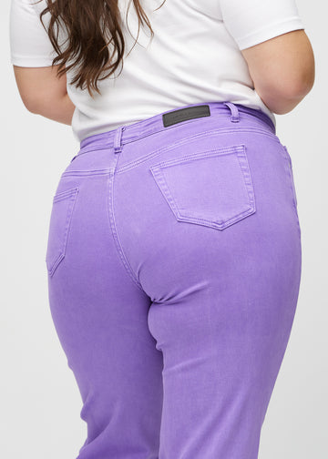Regular jeans for women in purple, color Lavenders. Close-up from behind on a plus-size model, showing fit and details.