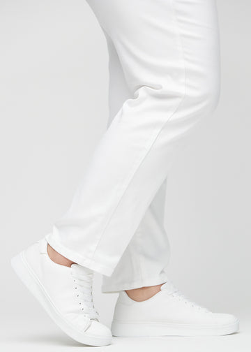 Regular jeans for women in white, color Marguerites. Close-up at the ankles on a plus-size model, showing the straight leg openings.