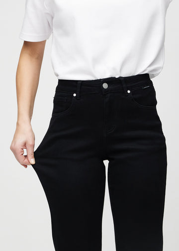 Regular jeans for women in black, color Ravens. A model stretches the fabric at the thigh to show its stretch.