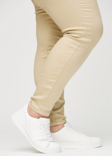 Skinny jeans for women in beige, color Gazelles. Close-up at the ankles on a plus-size model, showing the close-fitting leg openings.