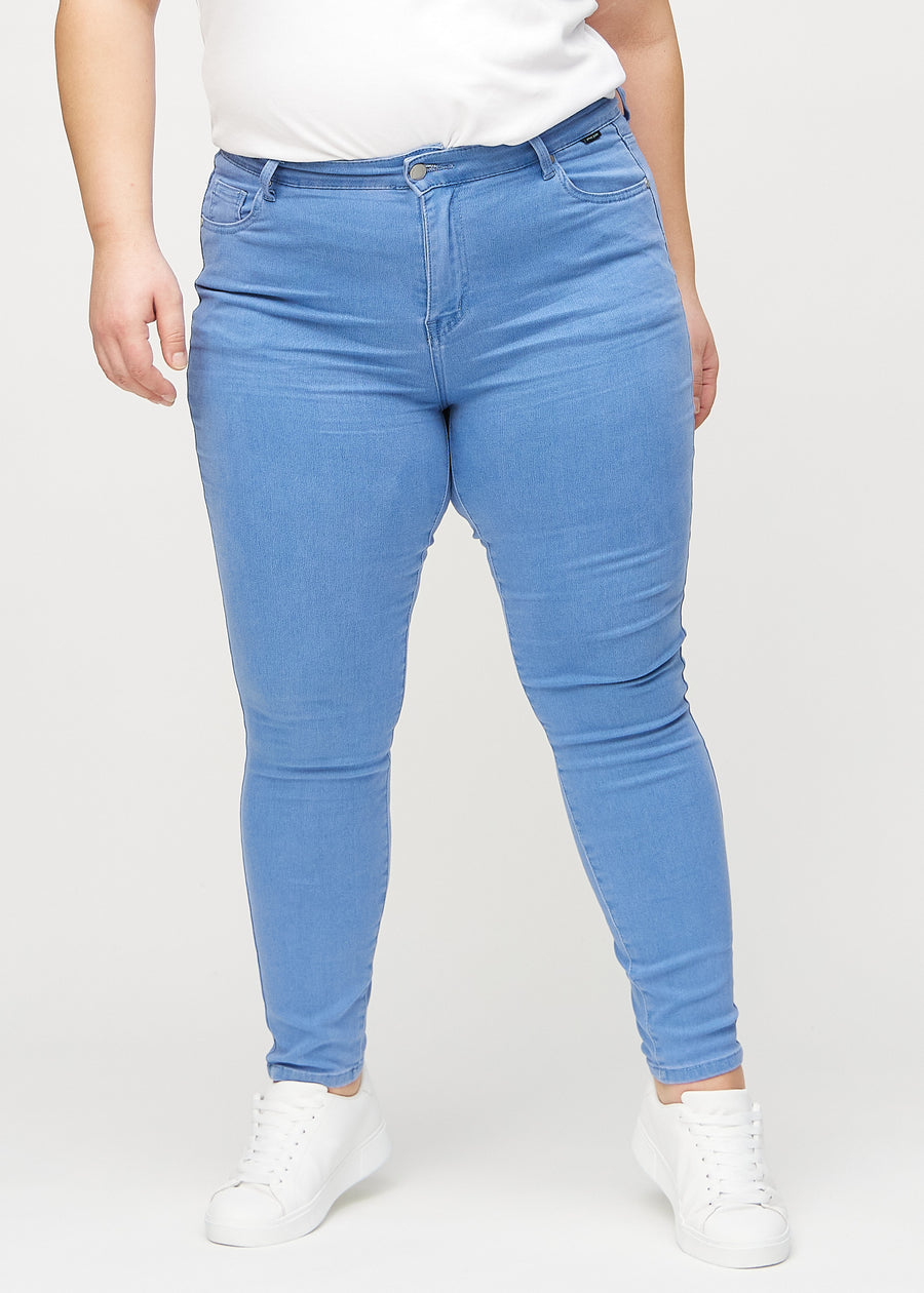 Skinny jeans for women in blue, color Geraniums. Front view on a plus-size model, showing the close fit through the legs.