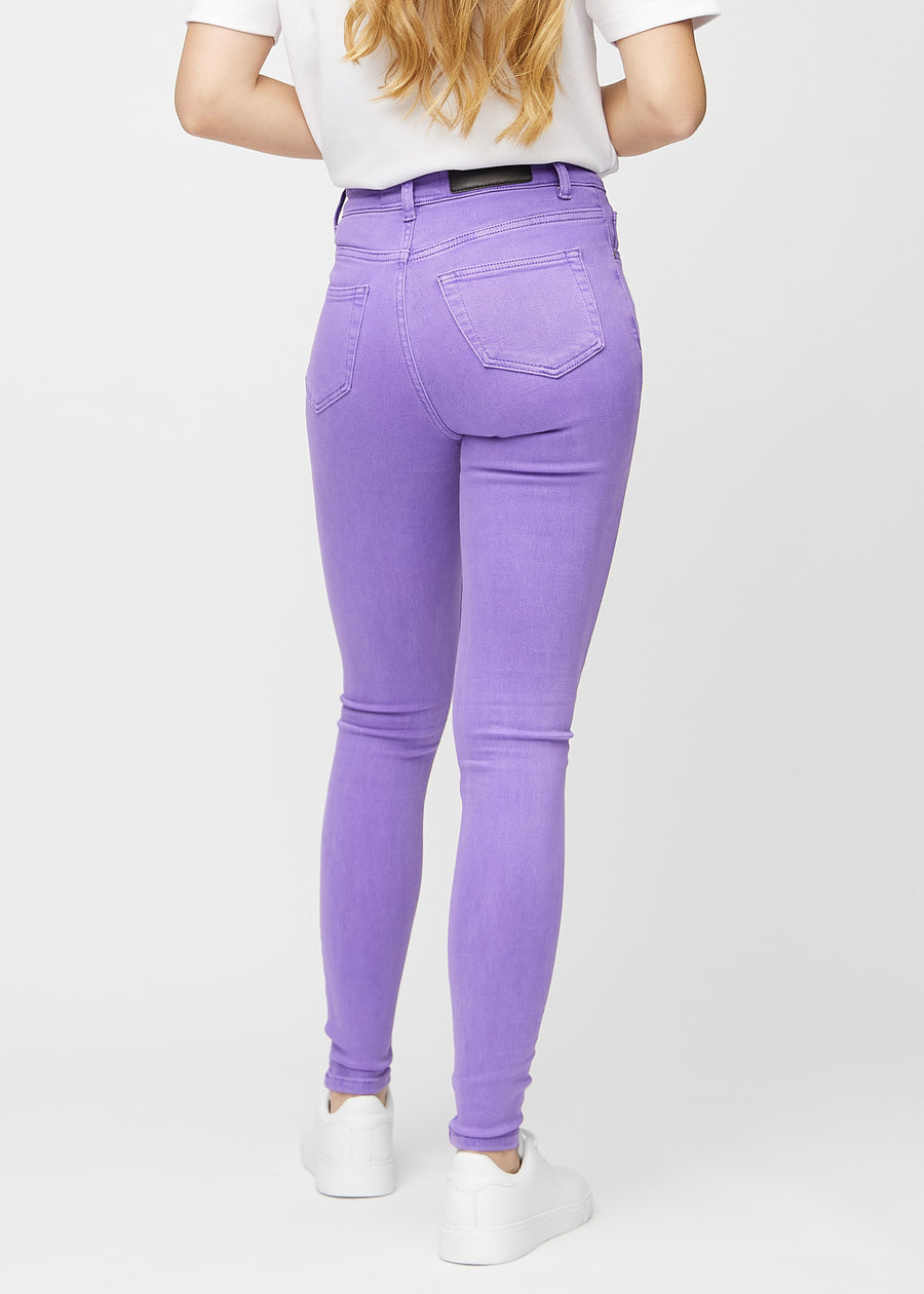 Skinny jeans for women in purple, color Lavenders. Back view on a model, showing the full fit.