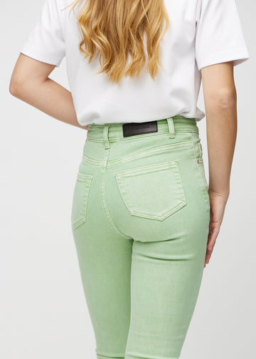 Light green skinny jeans seen from the back up close to show details.