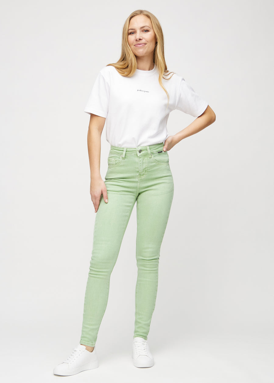 Full image of a model in light green skinny jeans.