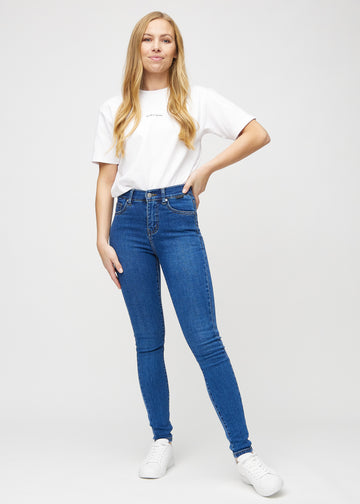 Full image of model in dark denim skinny jeans.