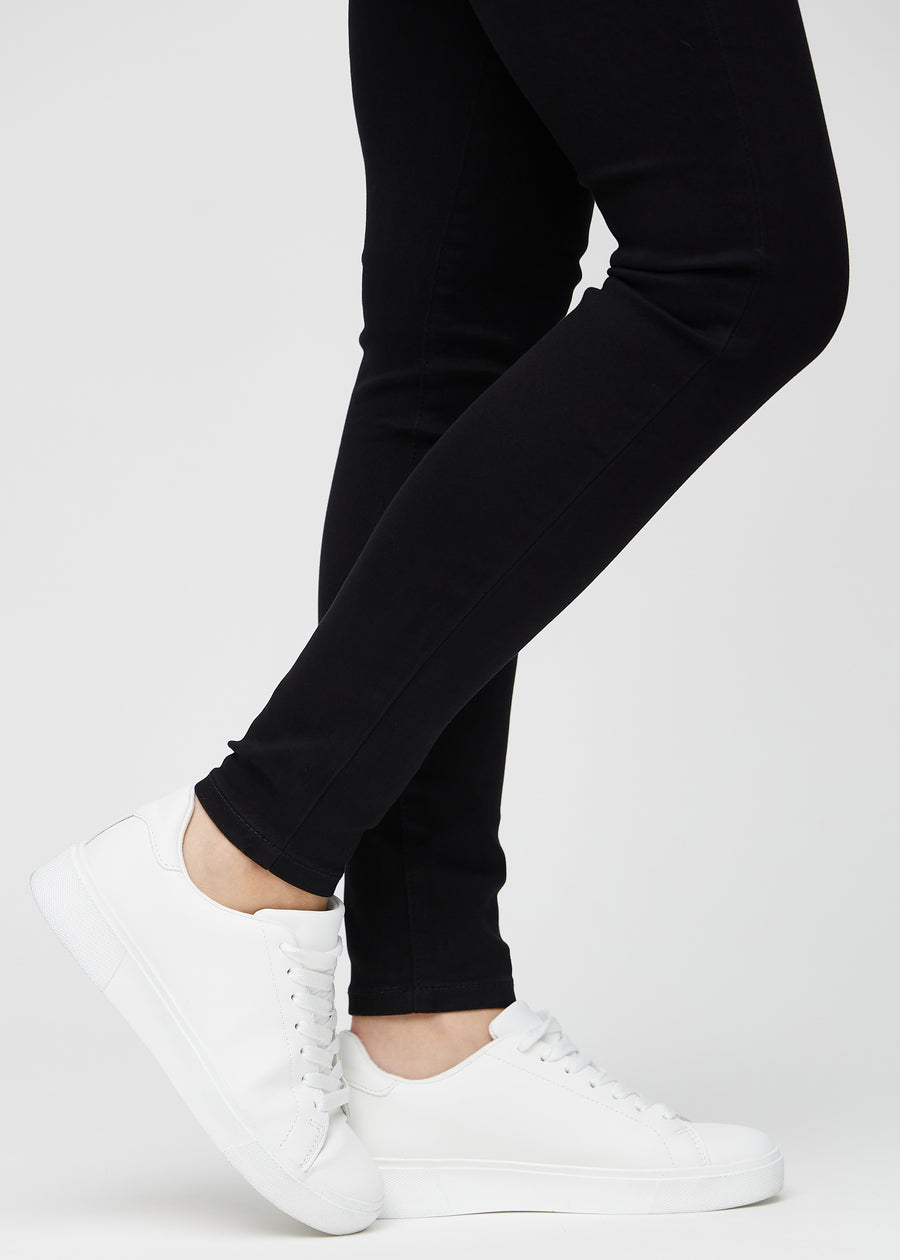 Skinny jeans for women in black, color Ravens. Close-up at the ankles on a model, showing the close-fitting leg openings.