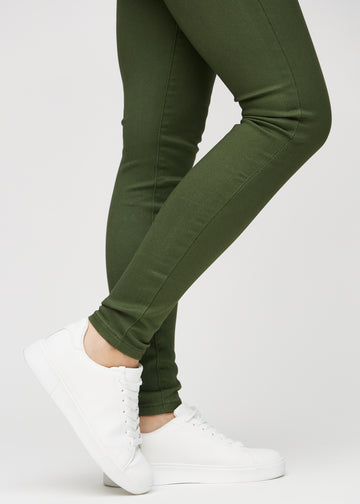 Skinny jeans for women in dark green, color Renewals. Close-up at the ankles on a model, showing the close-fitting leg openings.