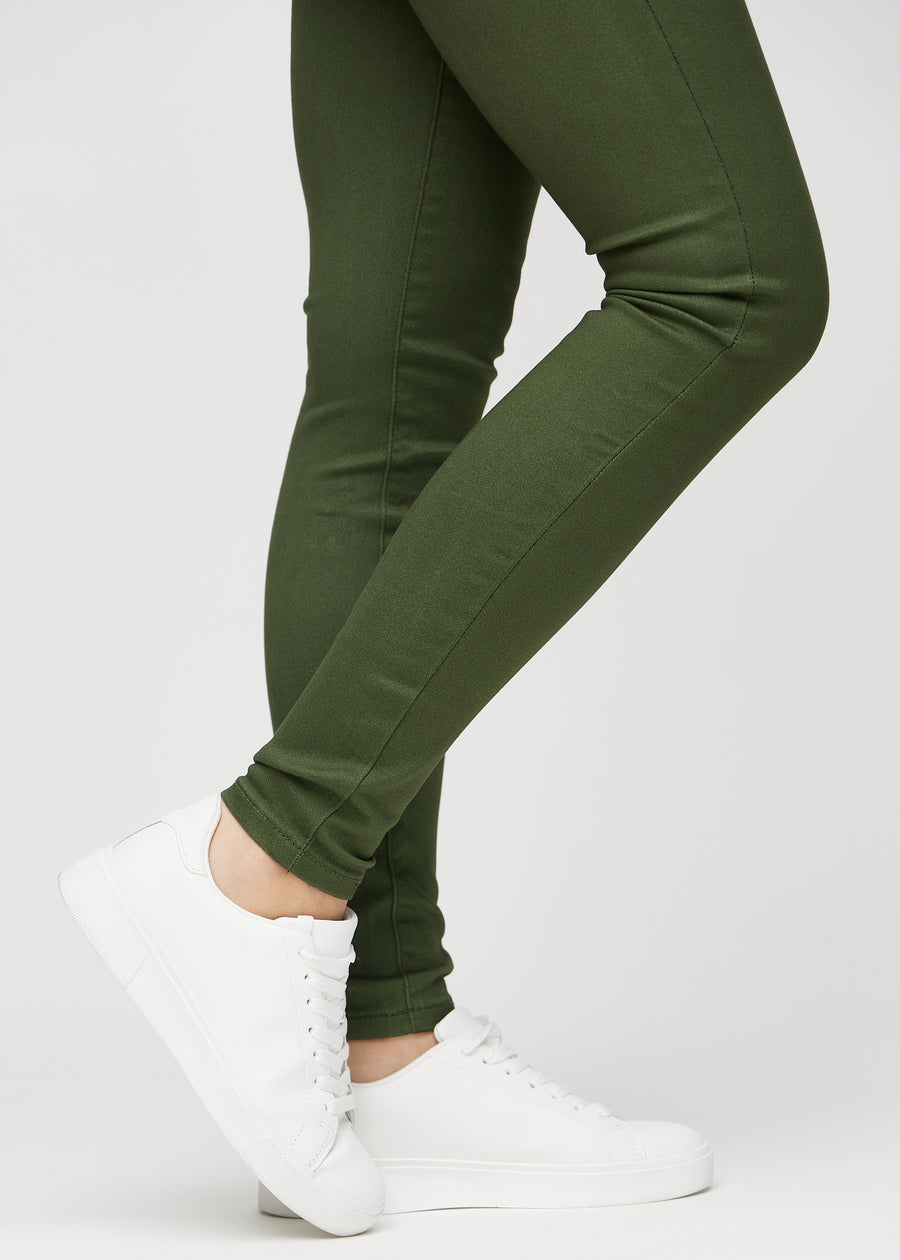 Skinny jeans for women in dark green, color Renewals. Close-up at the ankles on a model, showing the close-fitting leg openings.