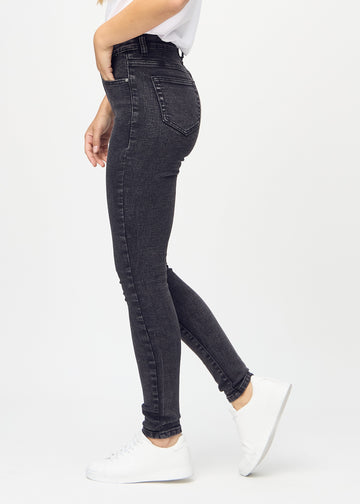 Dark grey denim skinny jeans seen from the side on a model.