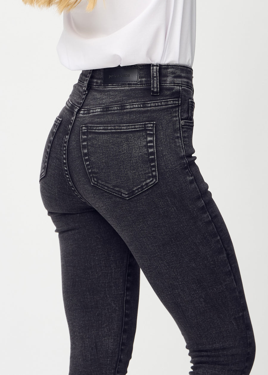 Dark grey denim skinny jeans seen from the back close up to show details.