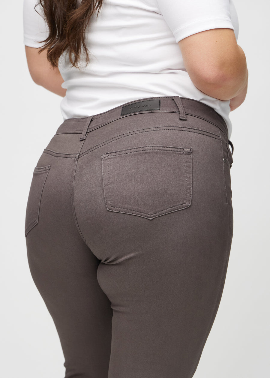 Skinny jeans for women in grey brown, color Thunders. Close-up back view on a plus-size model, showing details.
