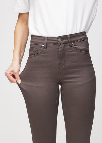 Skinny jeans for women in grey brown, color Thunders. A model stretches the jeans at the thigh to show the fabric&