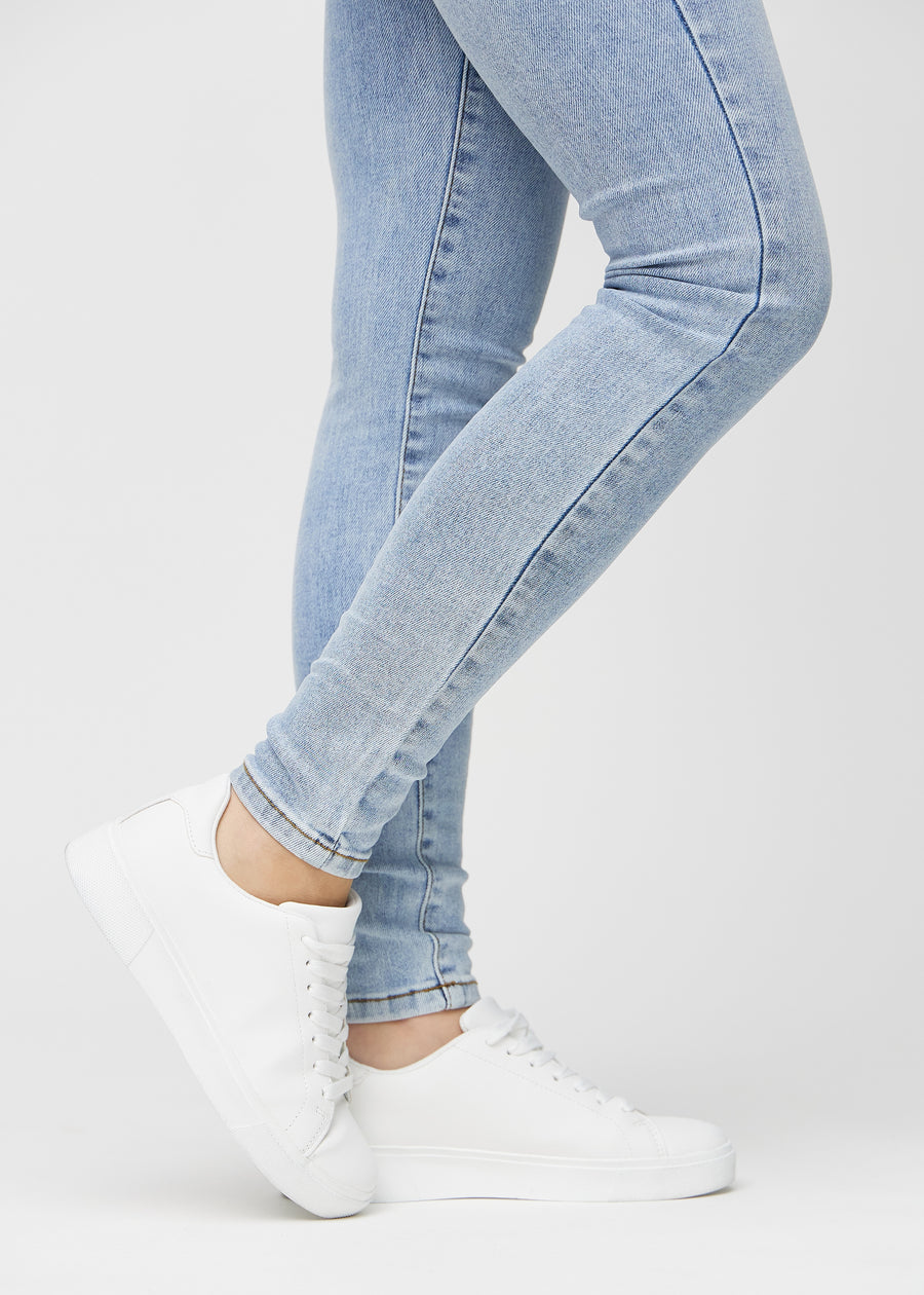 Skinny jeans for women in light blue, color Waves. Close-up of the snug-fitting leg openings at the ankles on a model.