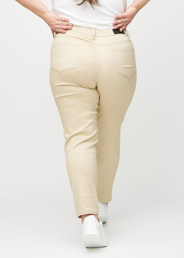 Beige slim jeans seen from behind on a plus-size model, so the entire product can be seen.
