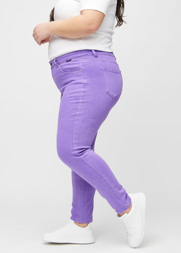 Slim jeans for women in purple, color Lavenders. Side view on a plus-size model.