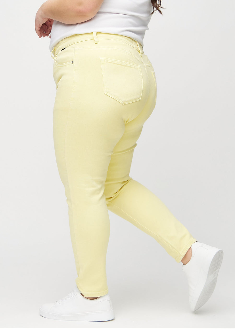 Slim jeans for women in light yellow, color Lemonades. Side view on a plus-size model.