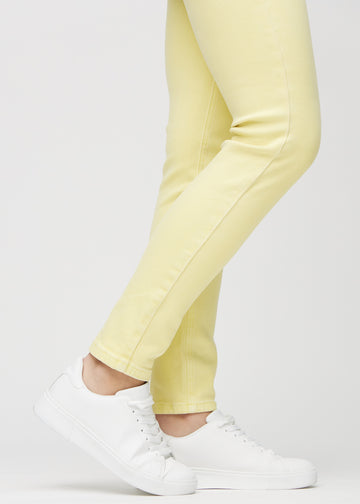 Slim jeans for women in light yellow, color Lemonades. Close-up at the ankles on a model, showing the fit at the leg openings.