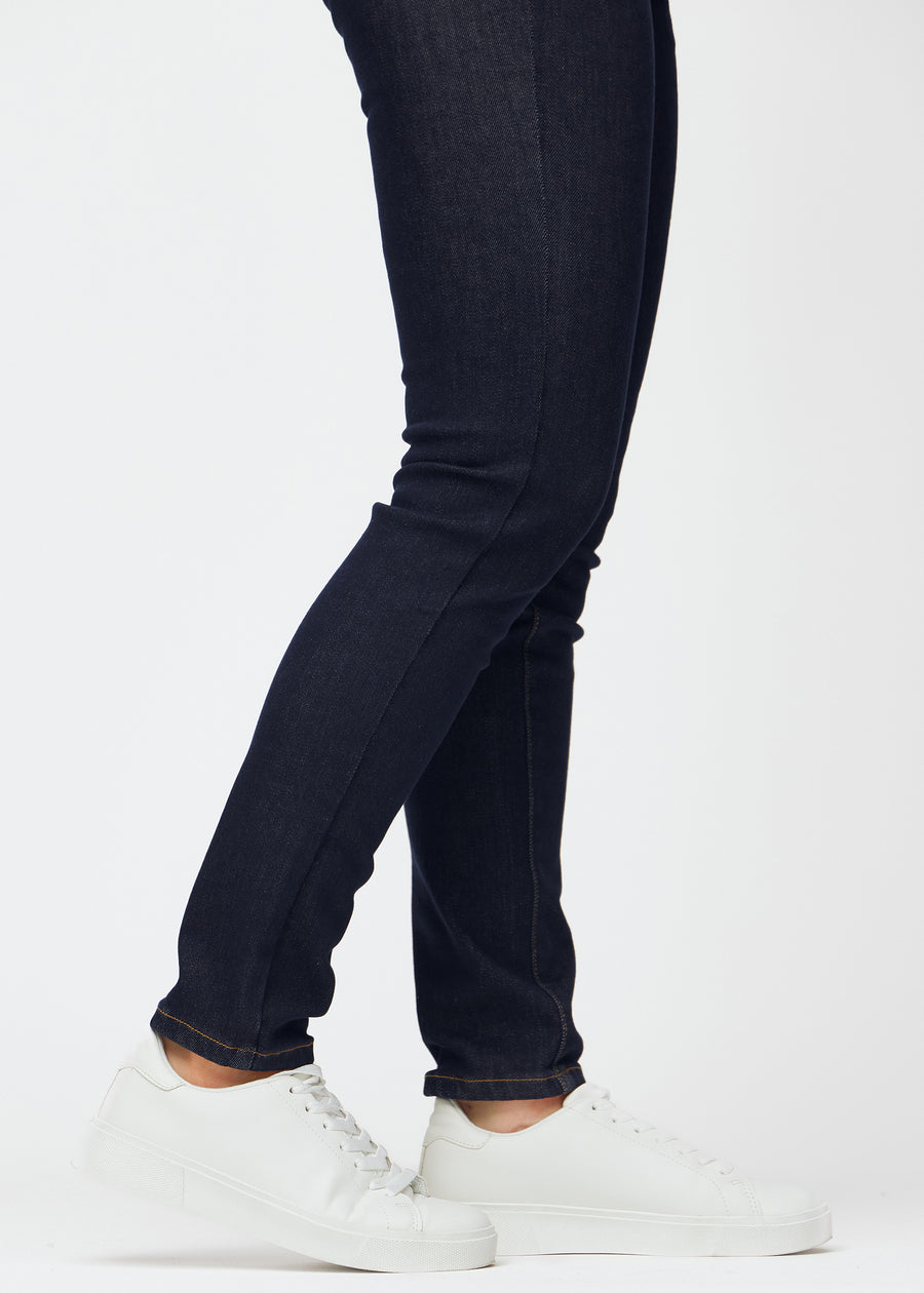 Deep dark blue denim jeans for women in the color Midnights with a slim fit shown in close-up at the ankles to show the tailored finish.