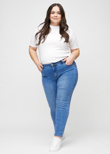 Slim jeans for women in blue, color Rivers. Full-length view of a plus-size model wearing the jeans.