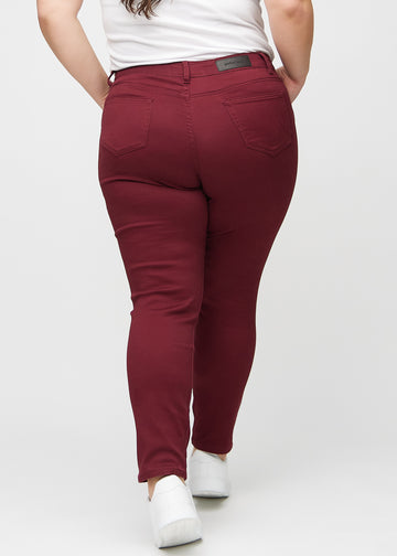 Slim jeans for women in dark red, color Santas. Back view on a plus-size model, showing the overall fit.