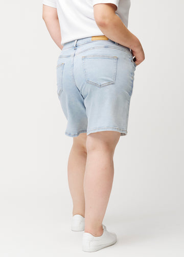 Lyseblå denimshorts til kvinder i farven Waves set bagfra på damemodel.