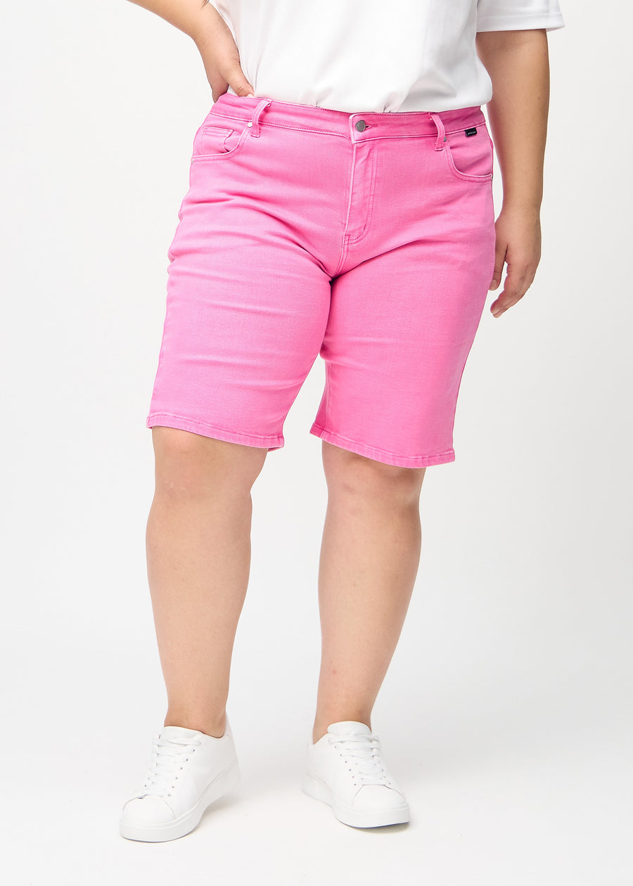 Light pink regular middle shorts, model name Flamingos, which fall straight down the leg and end just above the knee on a plus-size model, seen from the front.