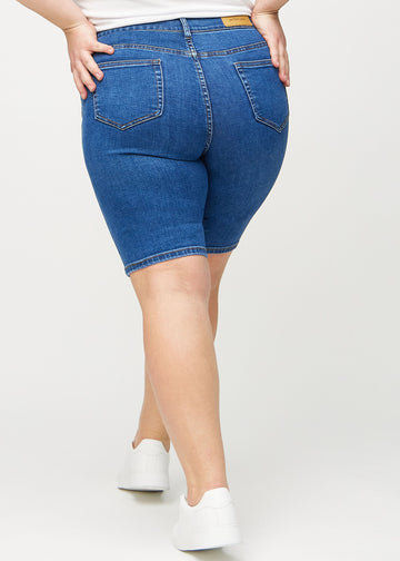 Dark denim skinny middle shorts seen from the back on a plus-size model, so the full product can be seen.