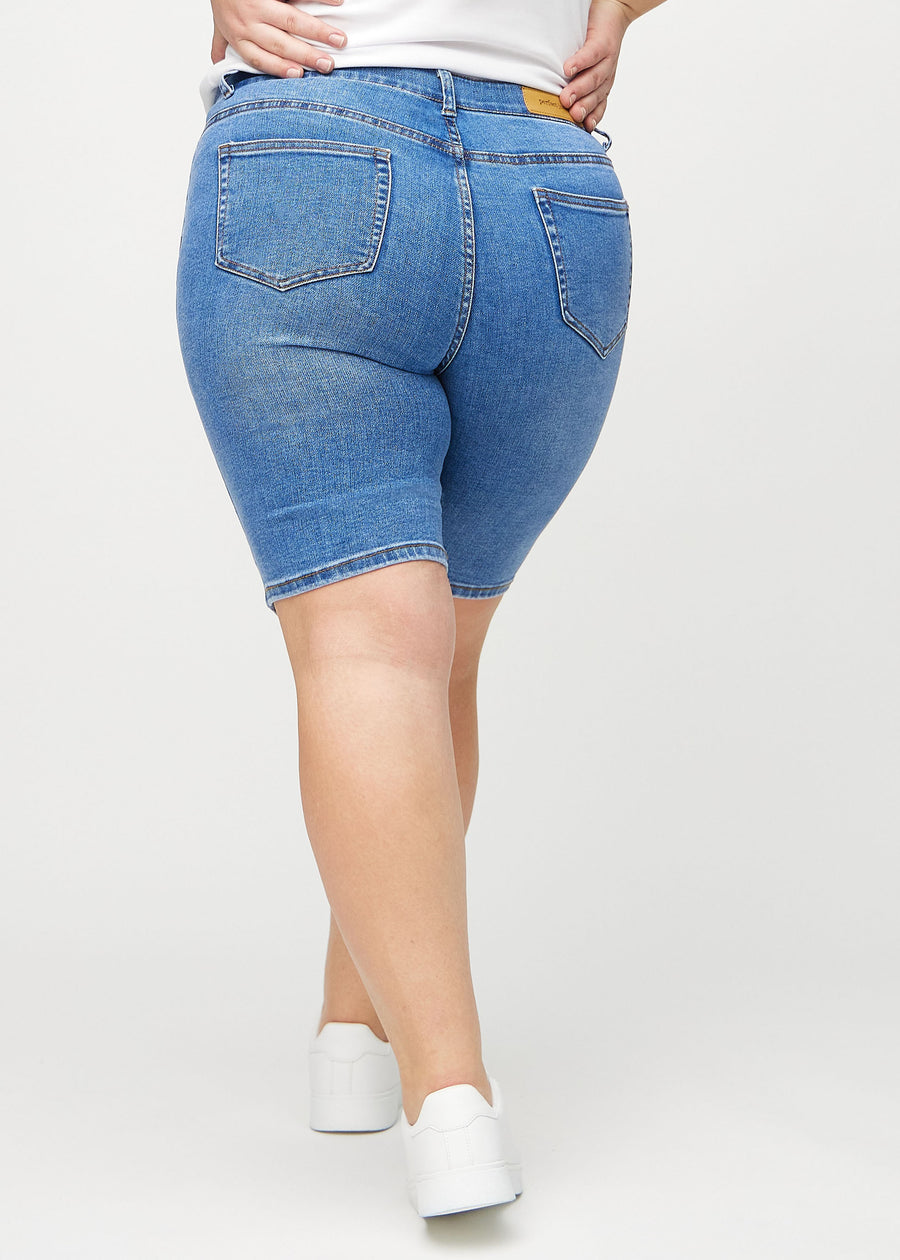 Denim skinny middle shorts seen from the back on a plus-size model, so the entire product can be seen.