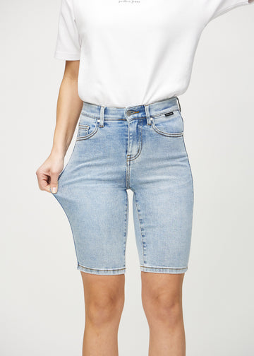The model stretches the shorts at the thigh to show the stretch.