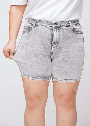 The plus-size model stretches the shorts at the thigh to show the stretch.