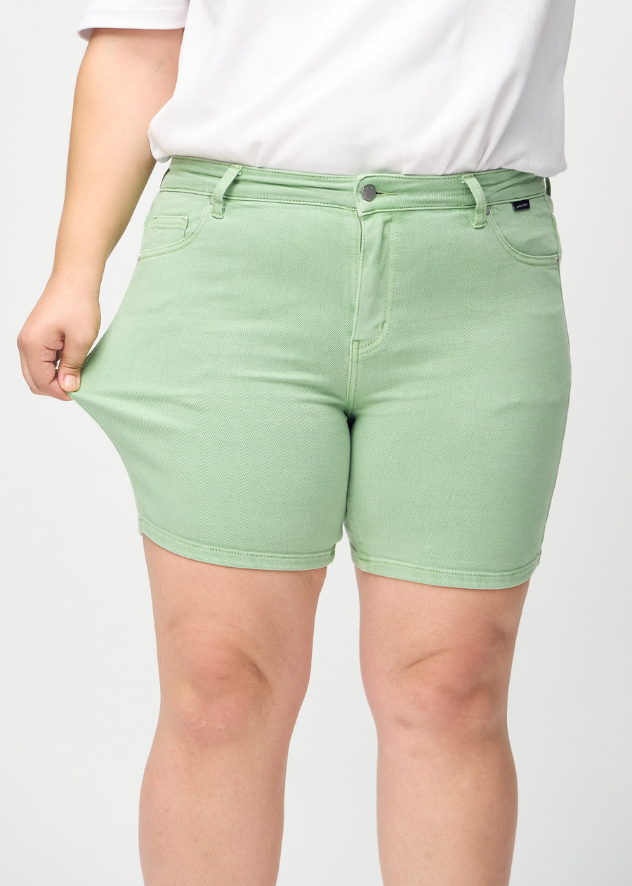 The plus-size model stretches the shorts at the thigh to show the stretch.