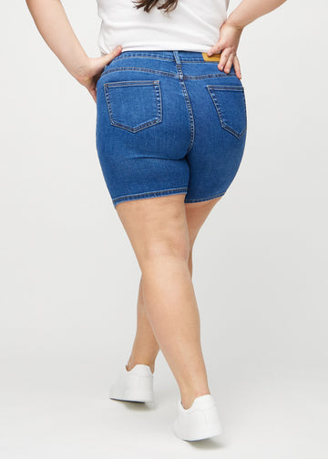 Dark denim skinny short shorts seen from the back on a plus-size model, so the entire product can be seen.