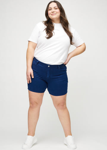 Full image of a plus-size model in dark blue skinny short shorts.