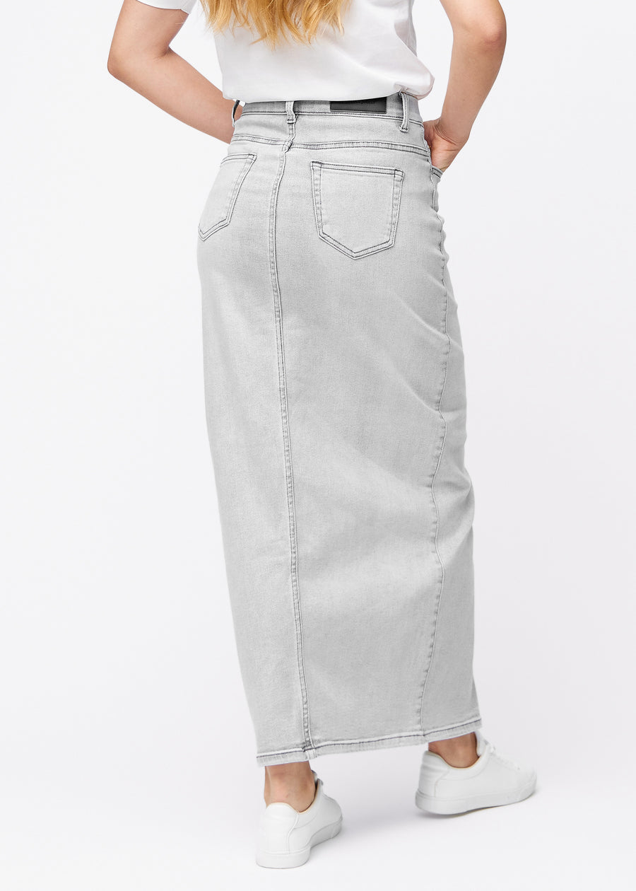 Long light grey denim skirt for women in the color Ashes. Back view on a model, showing the full length of the skirt.
