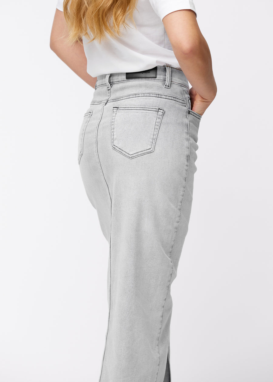 Long light grey denim skirt for women in the color Ashes. Close-up of the back on a model, showing the fit and details.