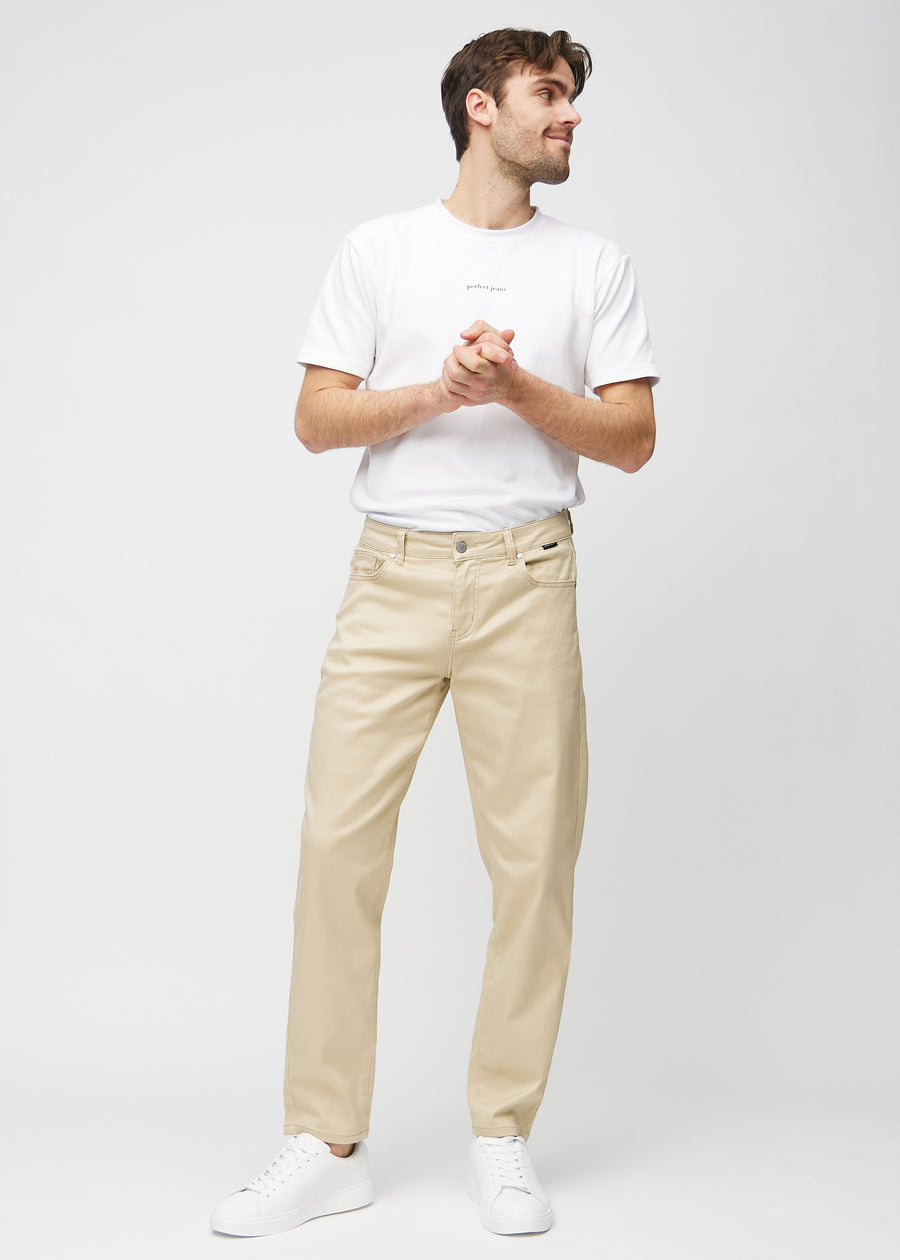 Full image of a model in beige regular jeans.
