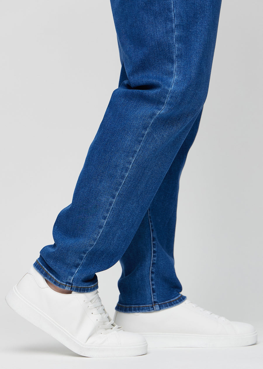 The ankles of a plus-size model, so you can see how loose the jeans fit.