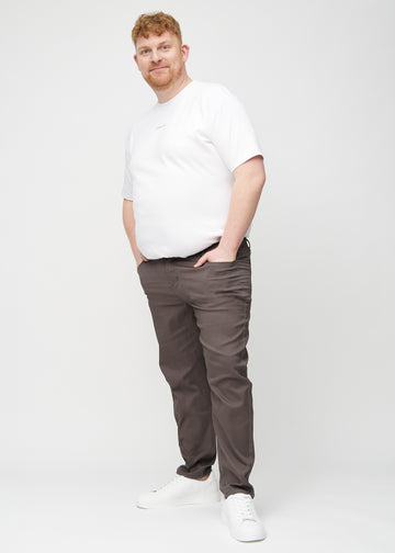 Full image of a plus-size model in grey-brown regular jeans.