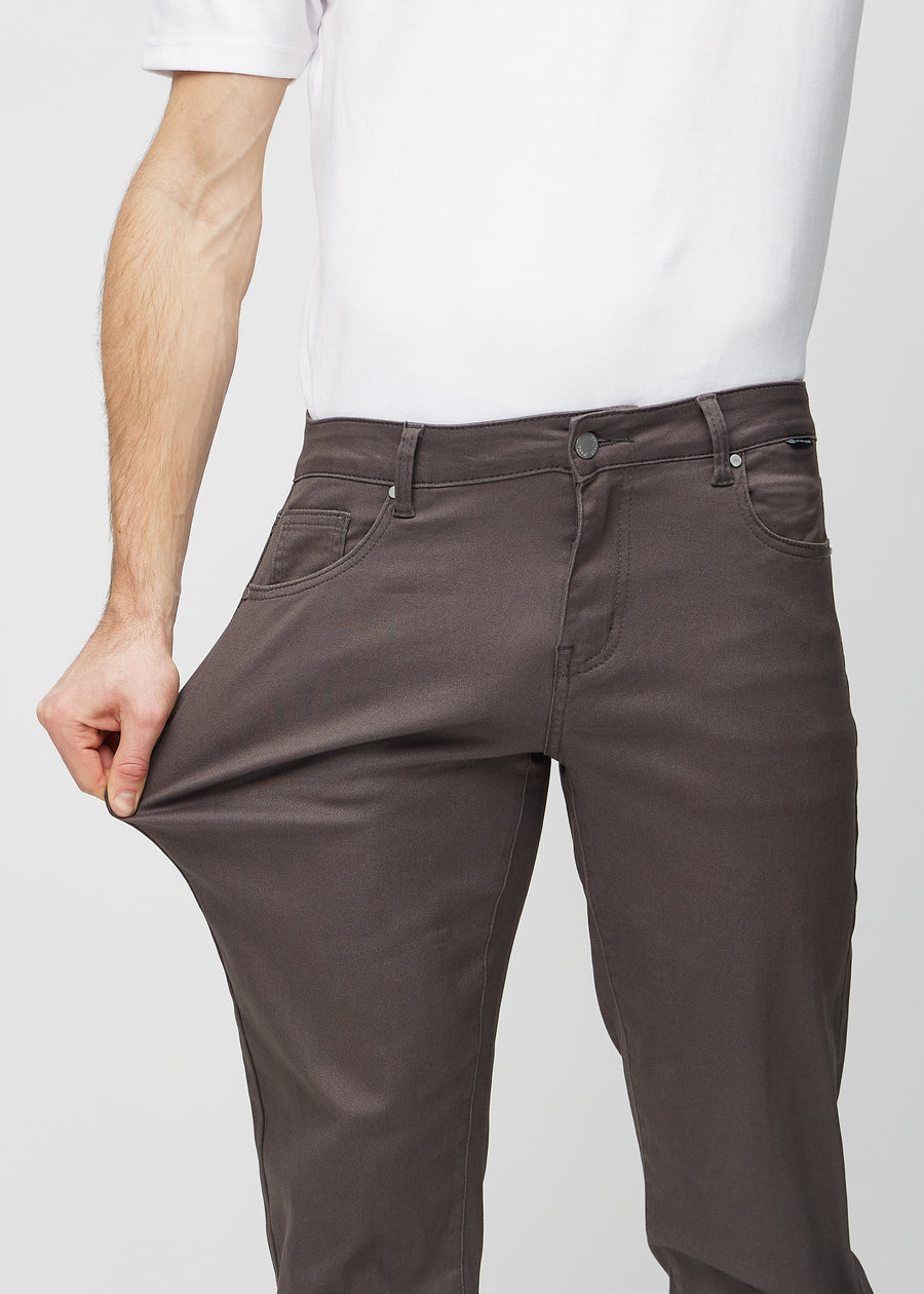 The model stretches the jeans at the thigh to show the stretch.