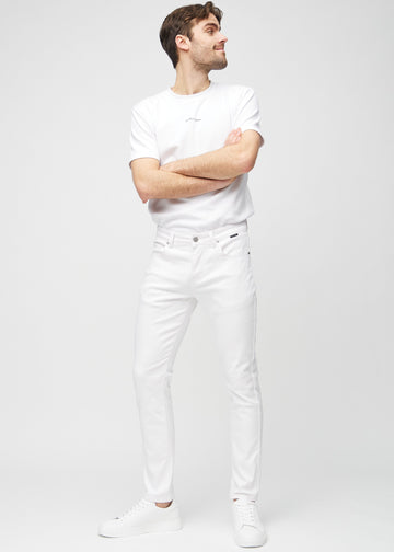 Full-length view of a model in white slim jeans.