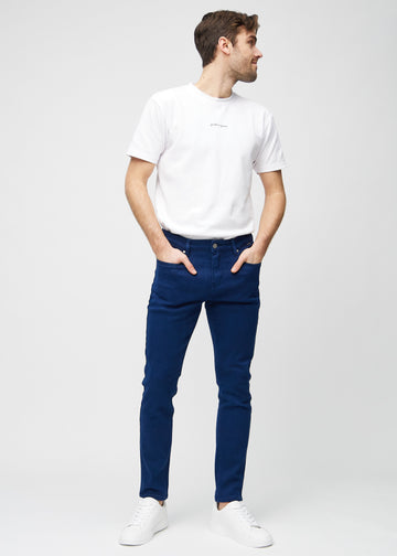 Full-length view of a model in dark blue slim jeans.