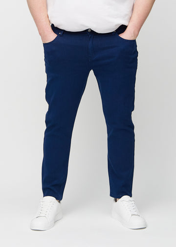 Dark blue slim jeans, model name Royals, fitted closely along the legs on a plus-size model, front view.