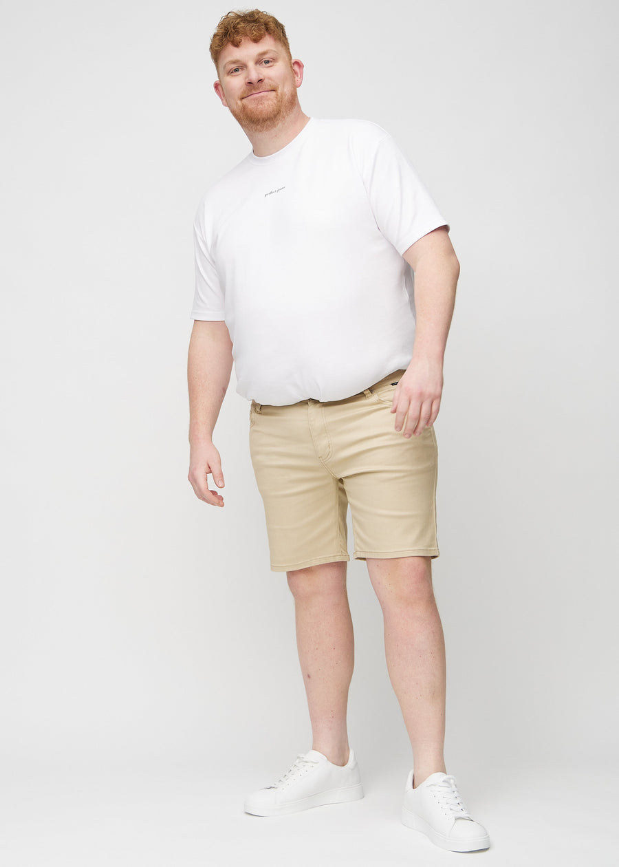Full image of a plus-size model in beige middle-slim shorts.