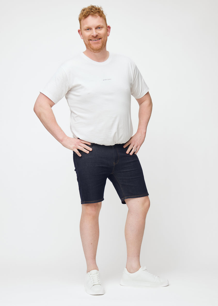 Full image of a plus-size model wearing deep dark blue denim shorts for men in the colour Midnights with a slim fit.