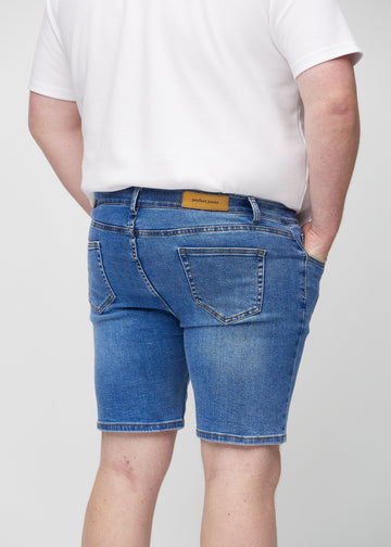 Denim middle-slim shorts seen from the back close up on a plus-size model to show details.