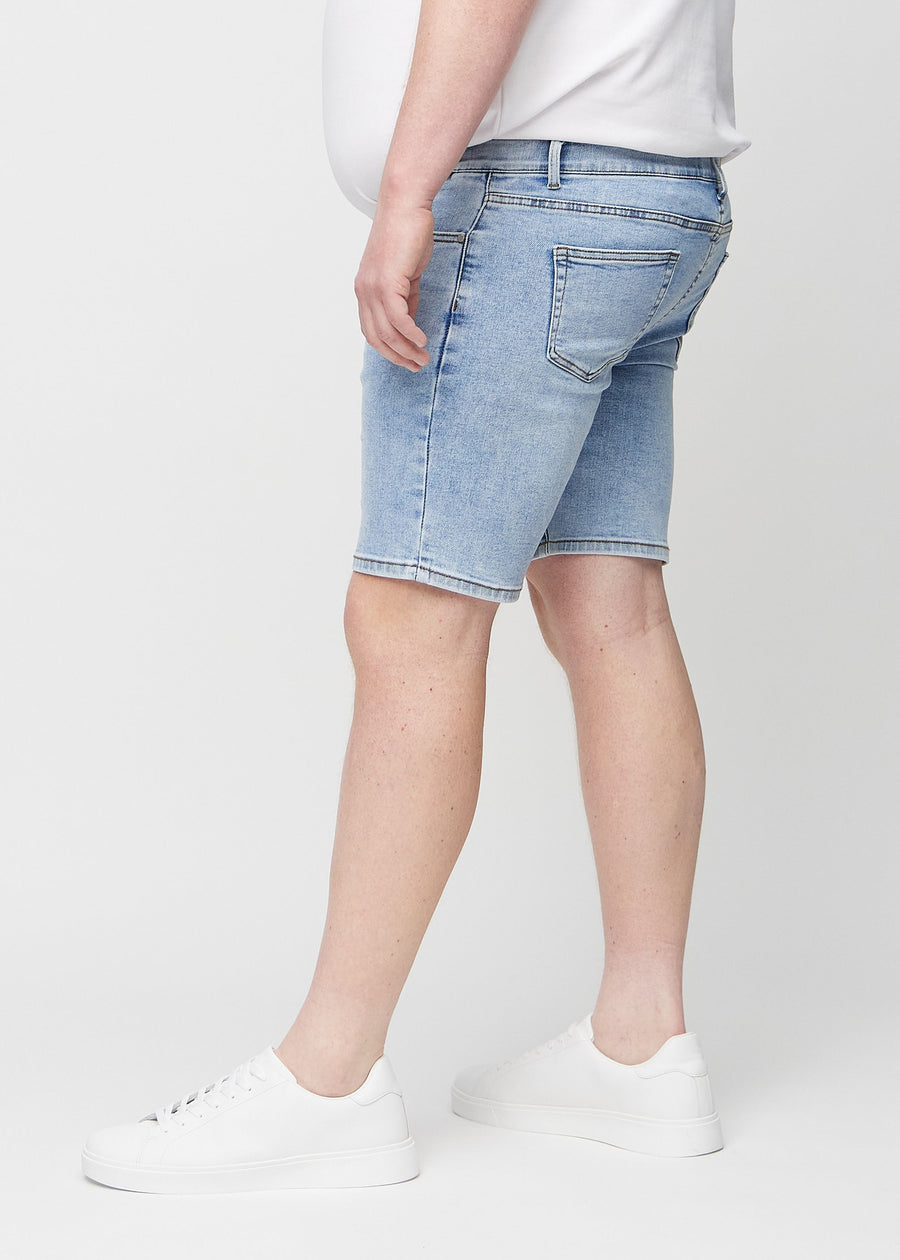 Light denim middle-slim shorts seen from the side on a plus-size model.