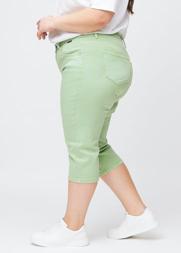 Lysegrønne slim capris i farven Mints – set fra siden på en plus-size model.
