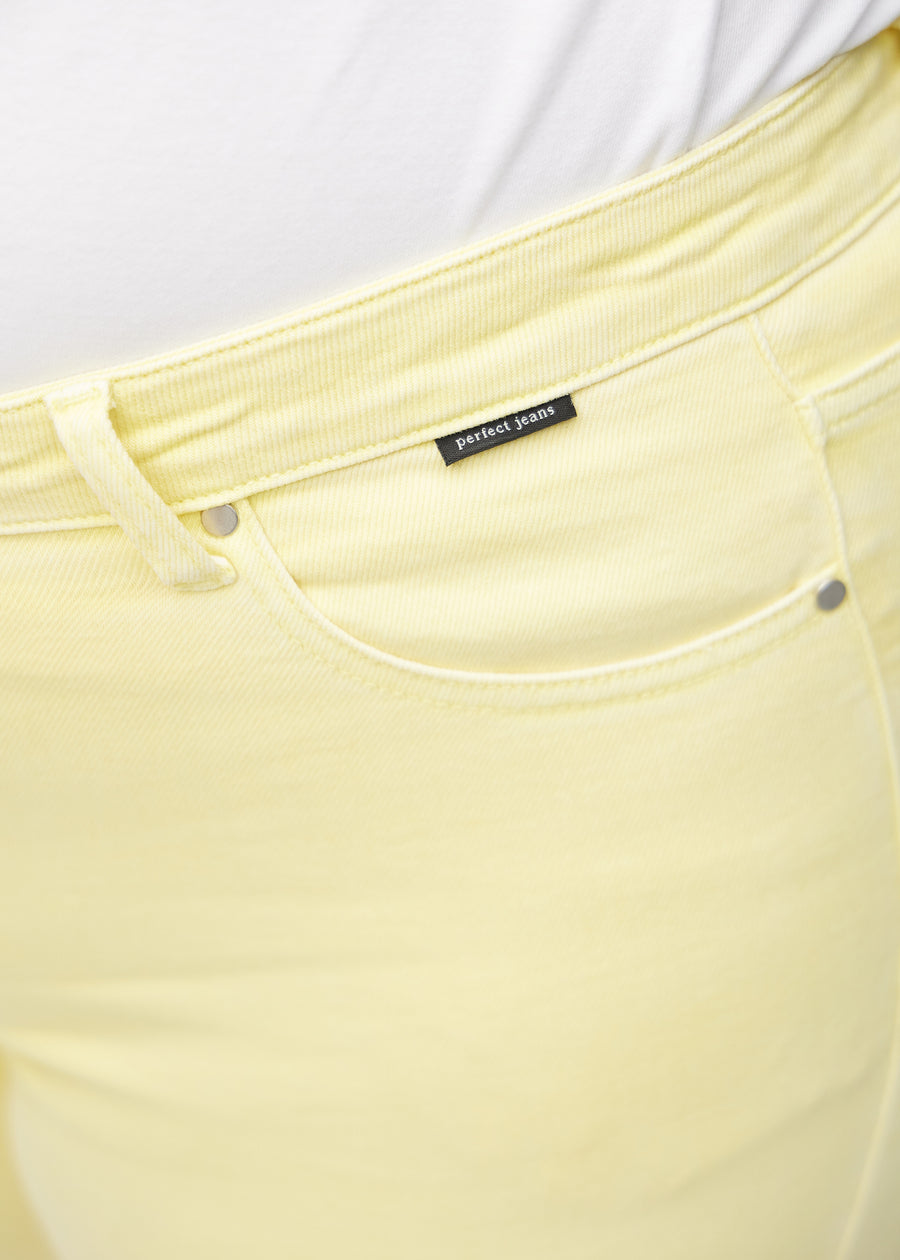 Detaljebillede af forlommen på de lysegule slim capris i farven Lemonades – logo og snit fremhævet.