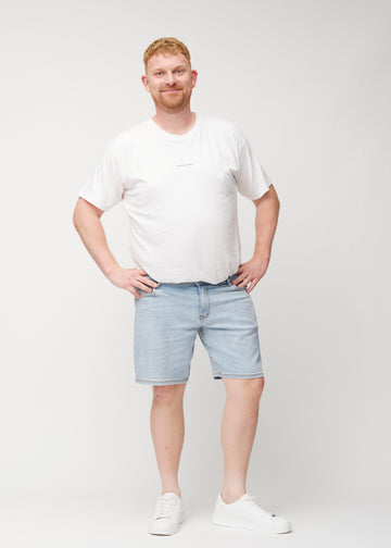 Plus-size model viser lyseblå denim shorts til mænd i farven Waves med regular pasform i bevægelse.